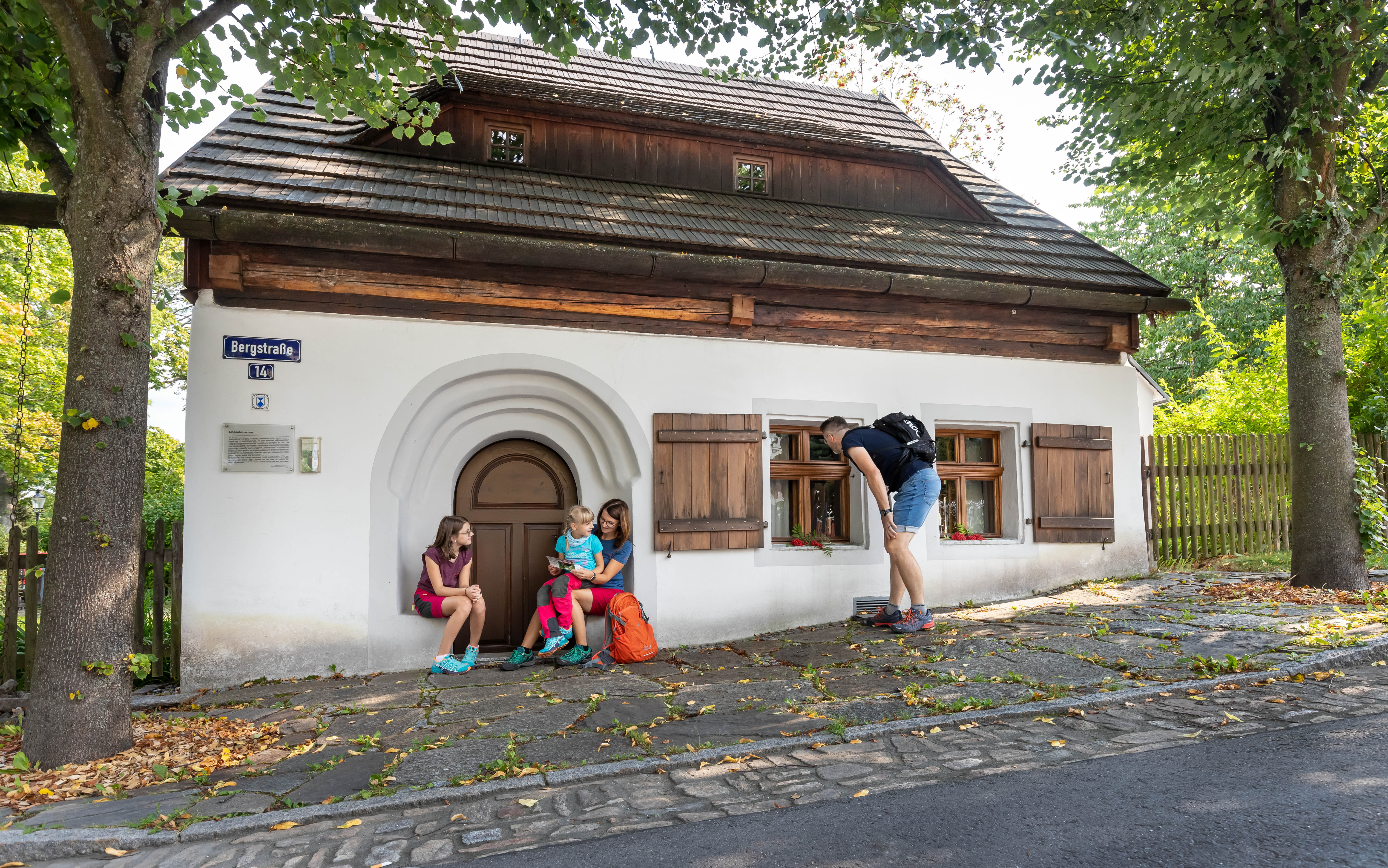 Familie vor Lindenhäuschen